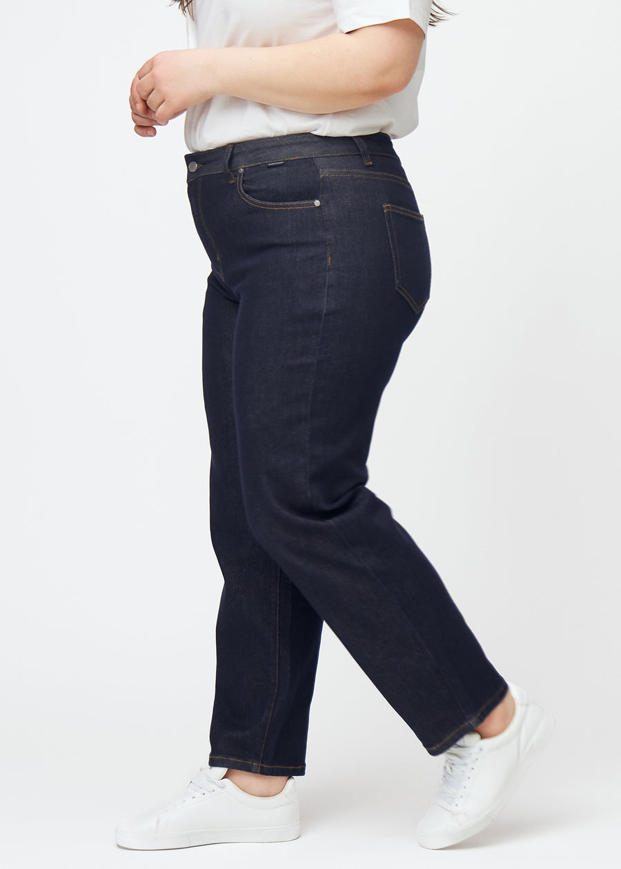 Deep dark blue denim jeans for women in the color Midnights with a regular fit, seen from the side on a plus-size model.