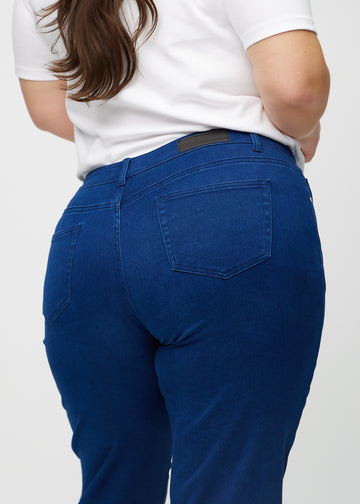 Regular jeans for women in dark blue, color Royals. Close-up from behind on a plus-size model, showing fit and details.