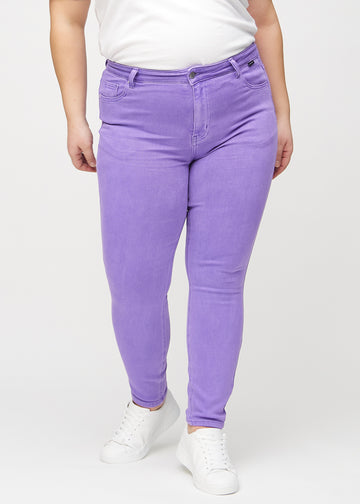 Skinny jeans for women in purple, color Lavenders. Front view on a plus-size model, showing the close fit through the legs.