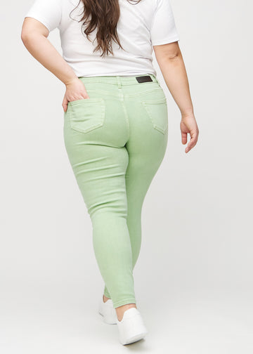 Skinny jeans for women in light green, color Mints. Back view on a plus-size model, showing the full fit.