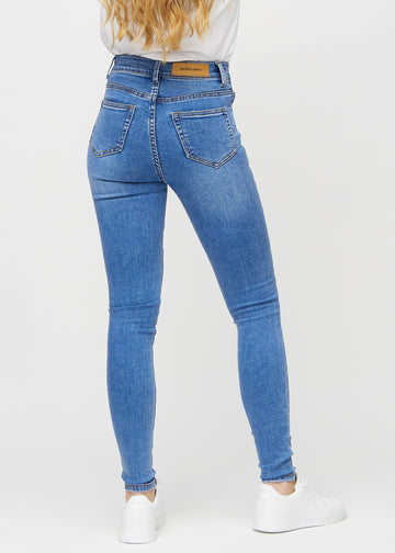 Skinny jeans for women in blue, color Rivers. Back view on a model, showing the full fit.