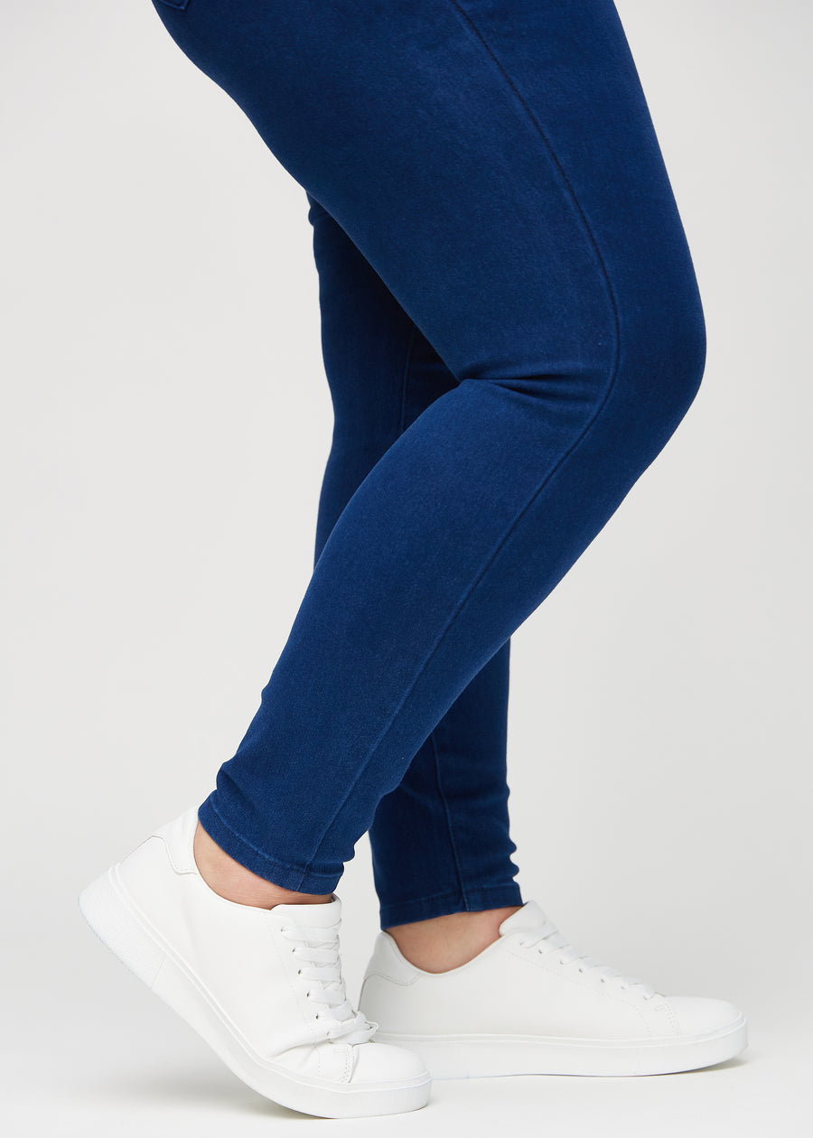 Skinny jeans for women in dark blue, color Royals. Close-up at the ankles on a plus-size model, showing the close-fitting leg openings.