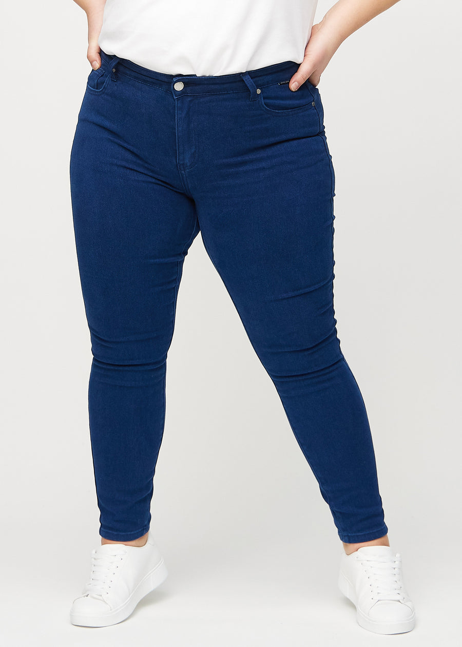 Skinny jeans for women in dark blue, color Royals. Front view on a plus-size model, showing the close fit through the legs.
