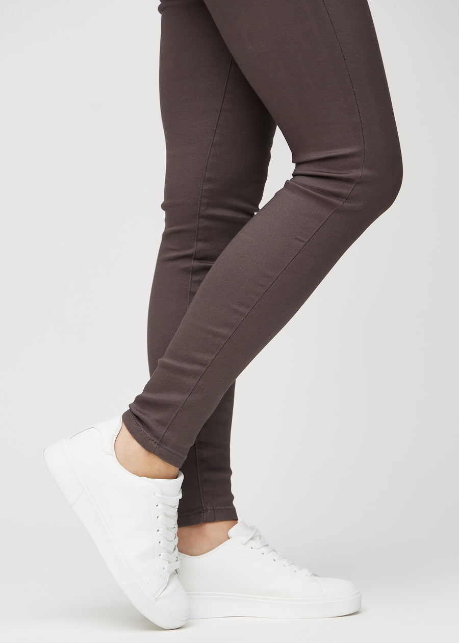 Skinny jeans for women in grey brown, color Thunders. Close-up of the snug-fitting leg openings at the ankles on a model.