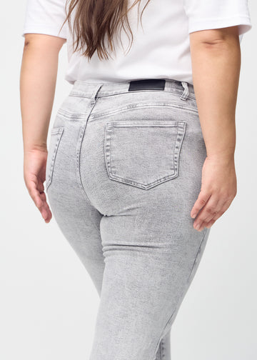Slim jeans for women in light grey, color Ashes. Close-up back view on a plus-size model, showing the details.