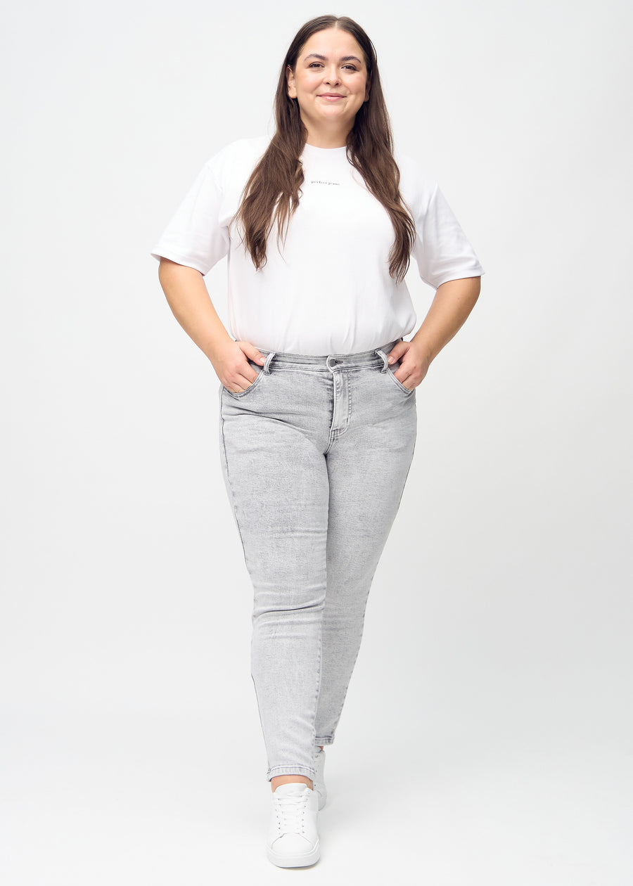 Slim jeans for women in light grey, color Ashes. Full-length view of a plus-size model wearing the jeans.