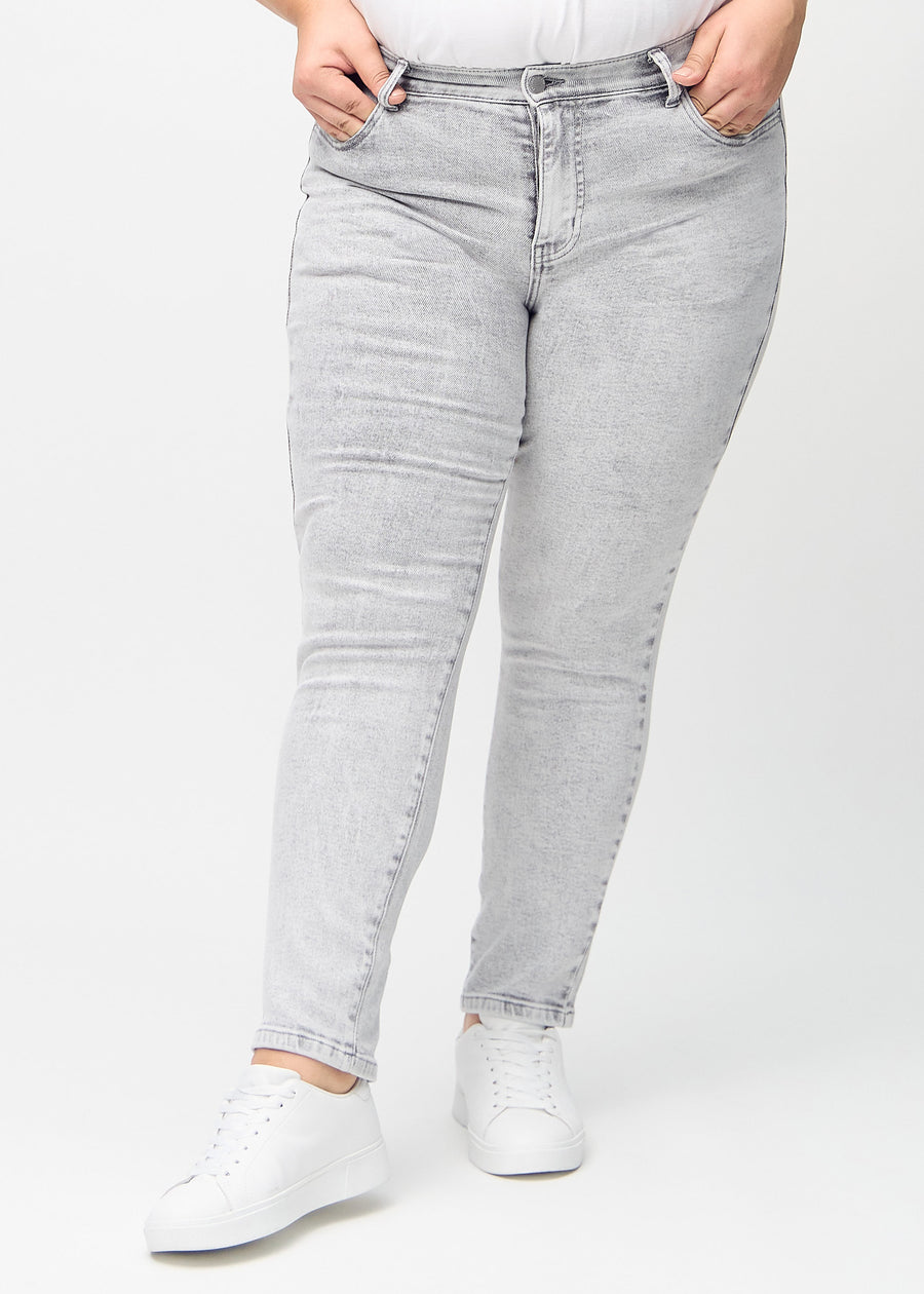 Slim jeans for women in light grey, color Ashes. Front view on a plus-size model, showing a close fit through the leg with a little more room at the ankle.