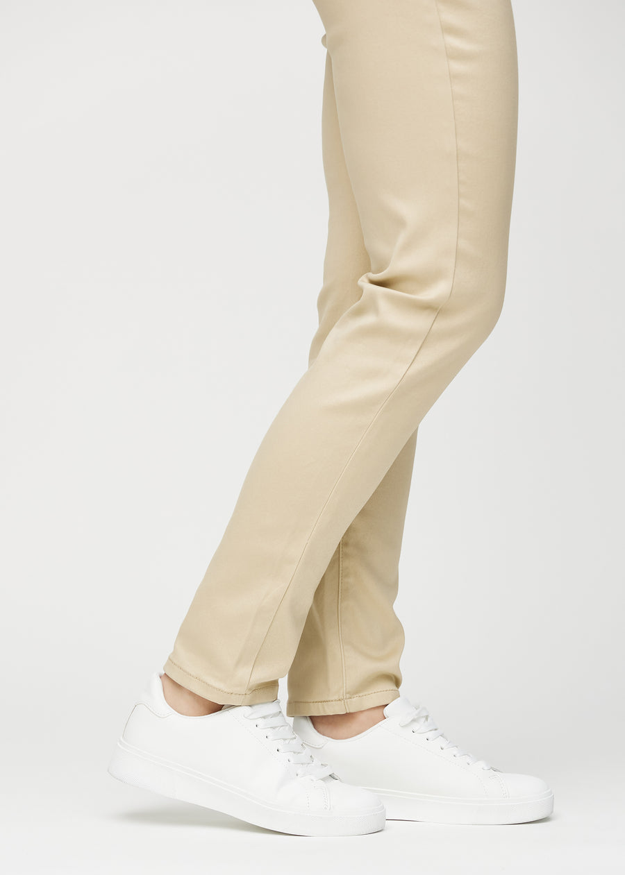 Slim jeans for women in beige, color Gazelles. Close-up at the ankles on a model, showing the fit at the leg openings.