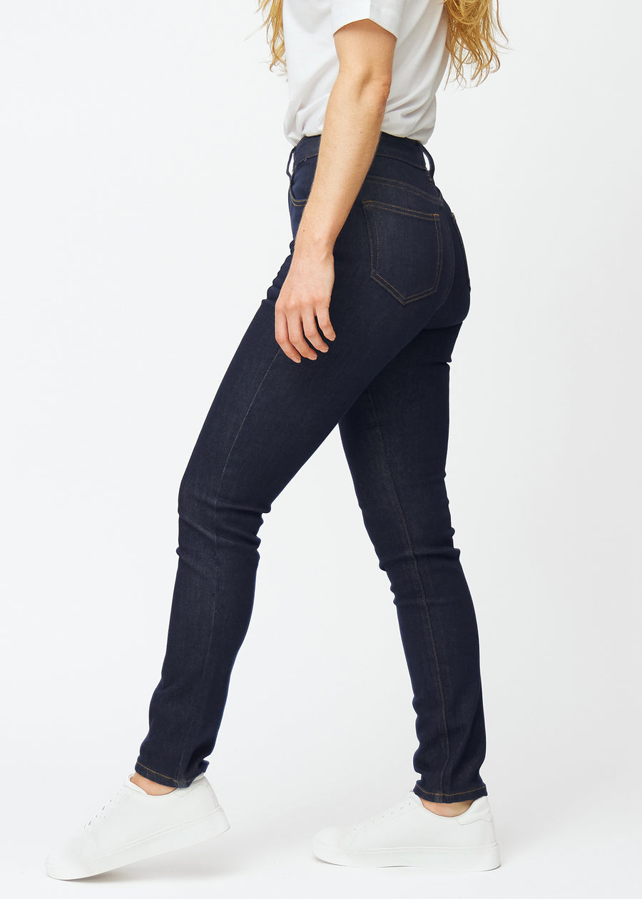 Deep dark blue denim jeans for women in the color Midnights with a slim fit seen from the side on a model.