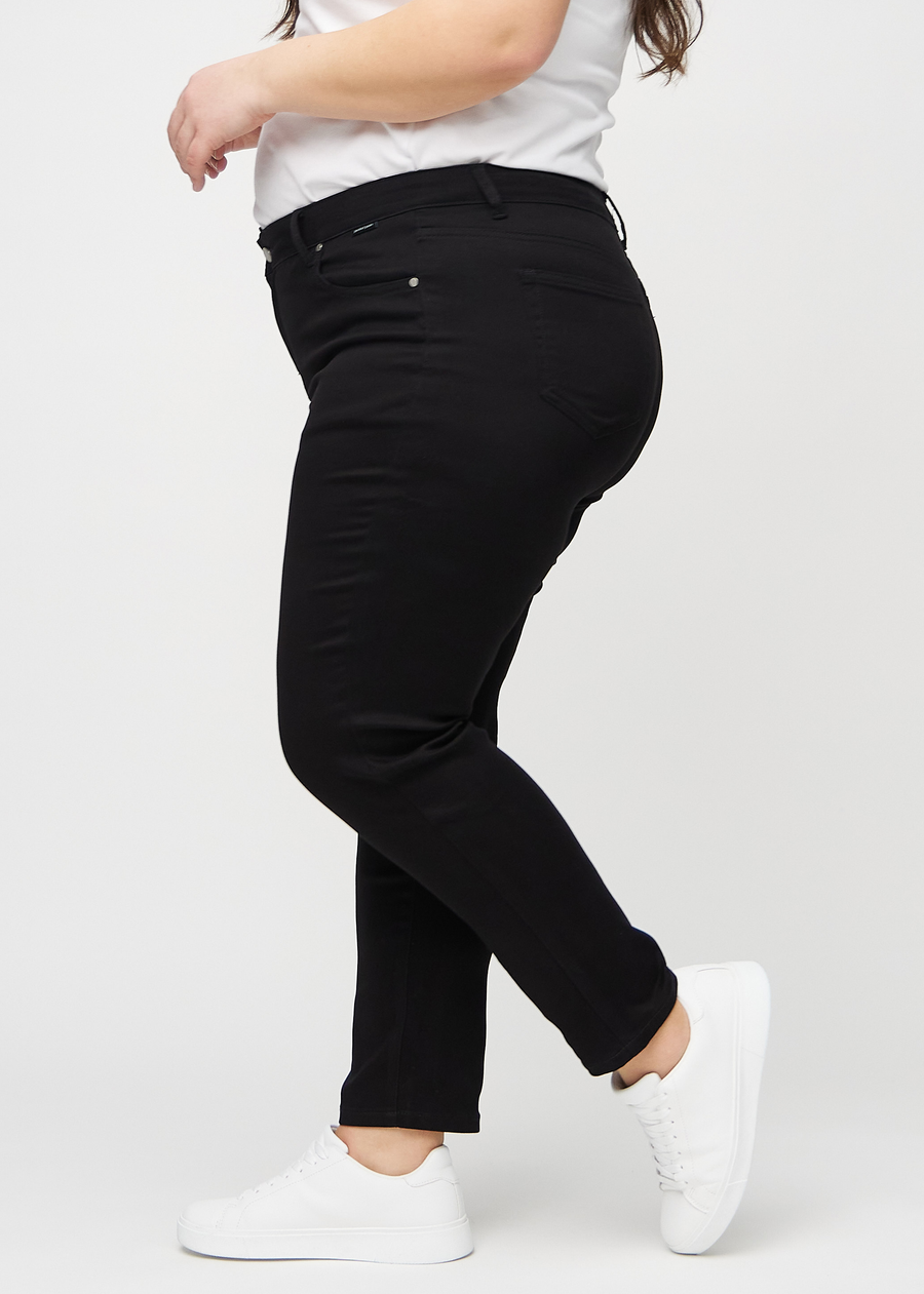 Slim jeans for women in black, color Ravens. Side view on a plus-size model.