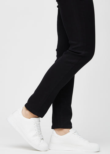 The ankles of a model, so you can see how closely the jeans fit in a Slim fit.
