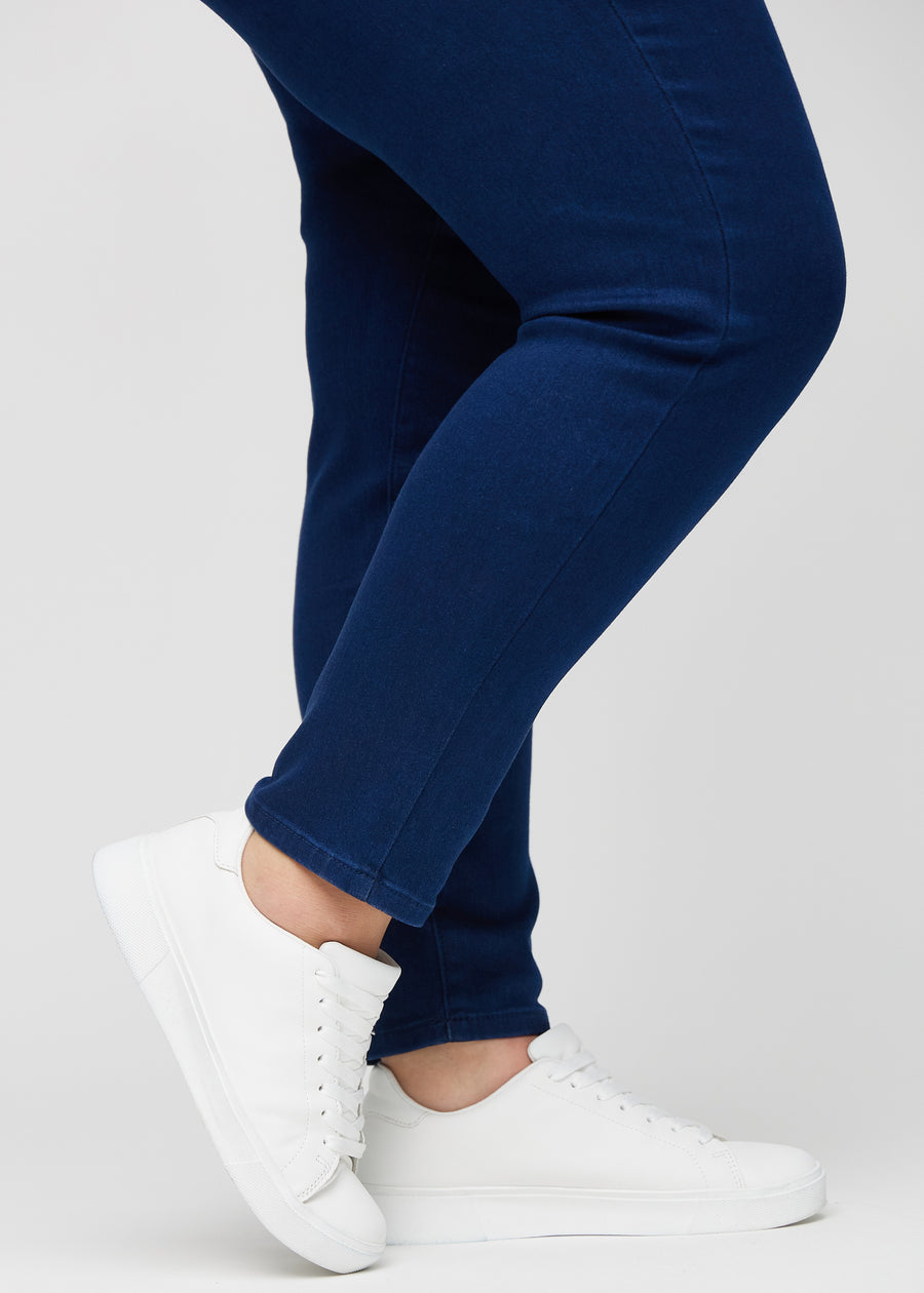 Slim jeans for women in dark blue, color Royals. Close-up at the ankles on a plus-size model, showing the fit at the leg openings.