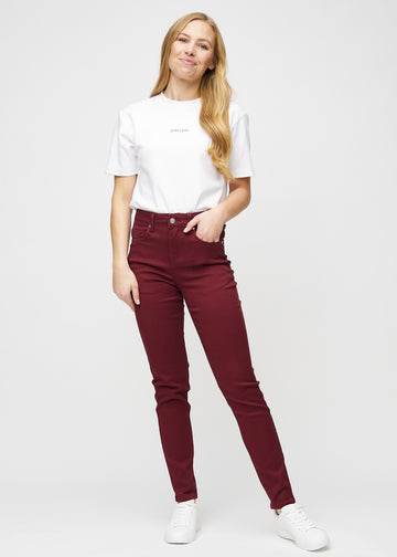 Slim jeans for women in dark red, color Santas. Full-length view of a model wearing the jeans.