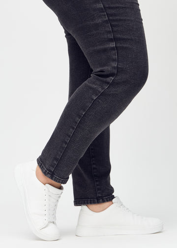Slim jeans for women in dark grey, color Shadows. Close-up at the ankles on a plus-size model, showing the fit at the leg openings.
