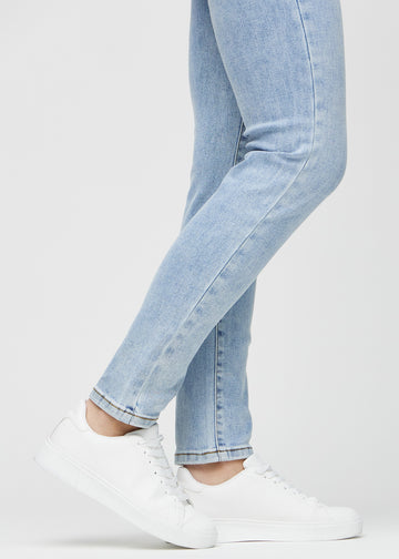 Slim jeans for women in light blue, color Waves. Close-up at the ankles on a model, showing the fit at the leg openings.