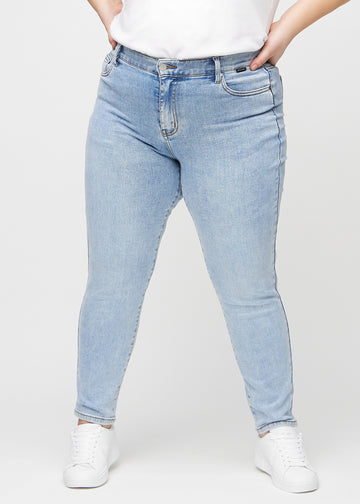 Slim jeans for women in light blue, color Waves. Front view on a plus-size model, showing a close fit through the leg with a little more room at the ankle.