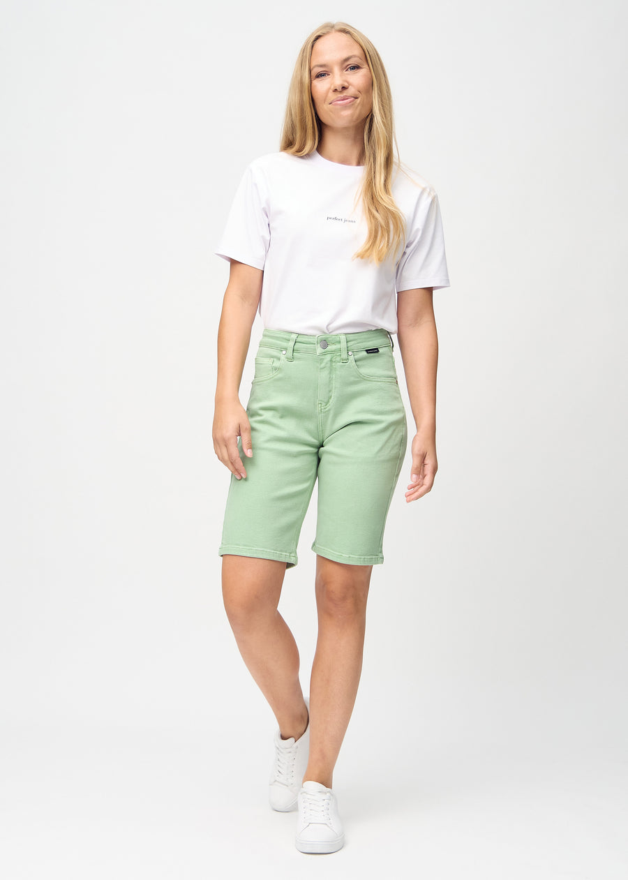 Full image of a model in light green regular middle shorts.