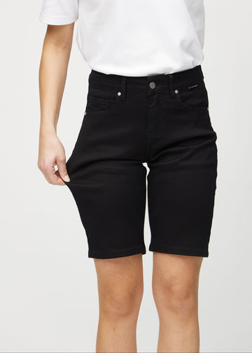 The model stretches the shorts at the thigh to show the stretch.