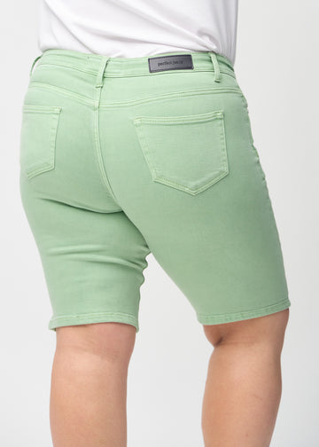 Light green skinny middle shorts seen from the back close up on a plus-size model to show details.