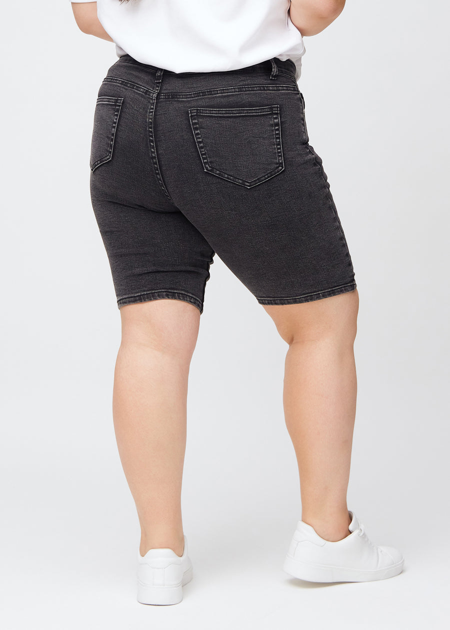 Woman in dark grey denim shorts seen from the back