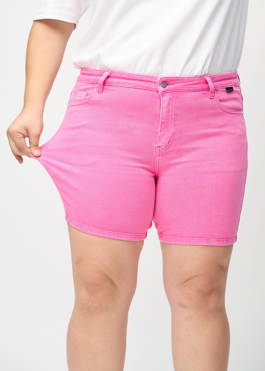 The plus-size model stretches the shorts at the thigh to show the stretch.