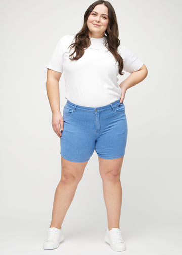 Full image of a plus-size model in blue skinny short shorts.