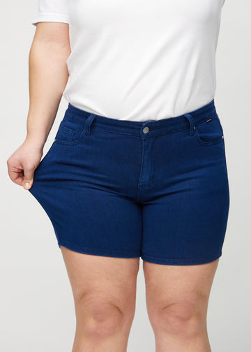 The plus-size model stretches the shorts at the thigh to show the stretch.