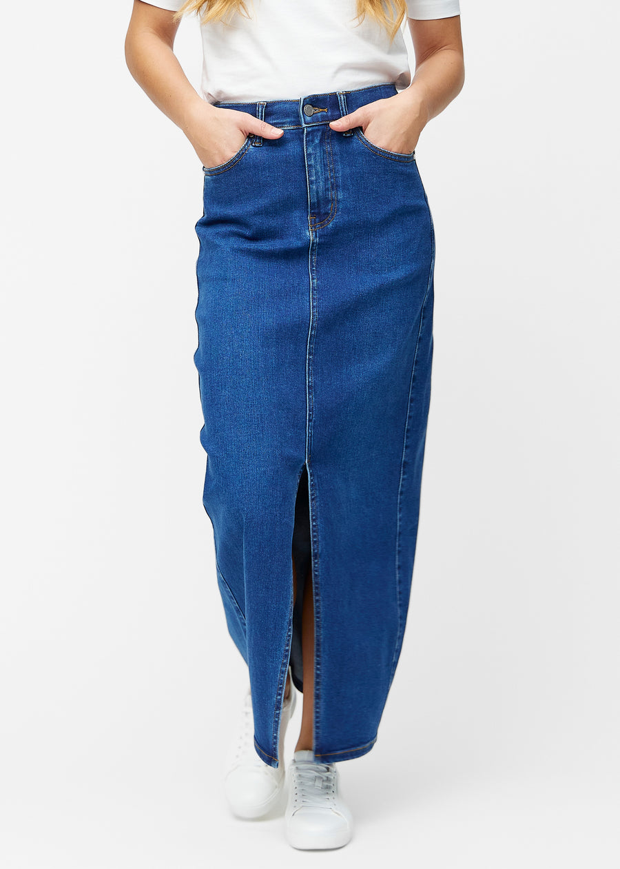 Lang, mørkeblå denimnederdel i farven Oceans med regulær pasform, der sidder tæt til hoften og falder lige ned til anklerne, med slids foran der starter lige under knæet, set forfra.