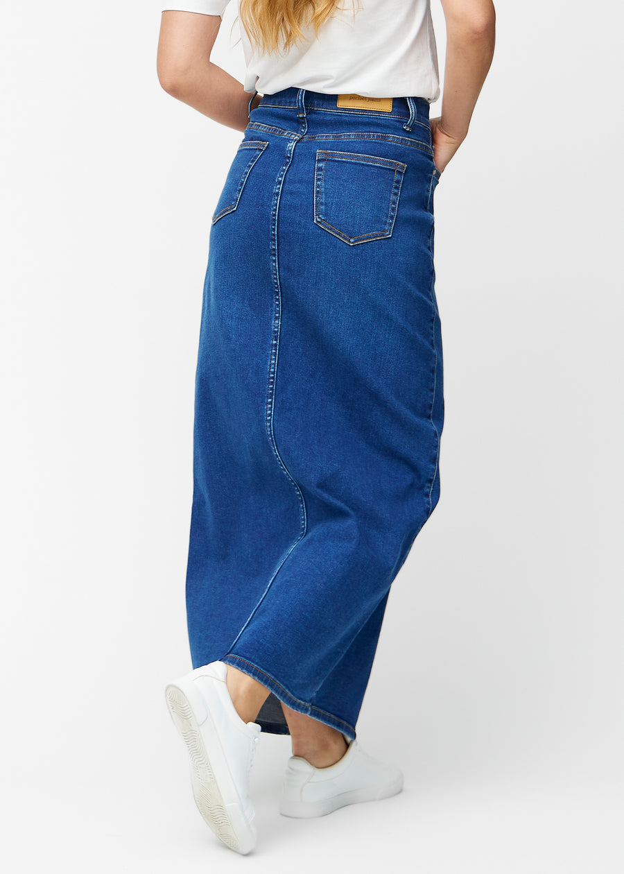 Lang, mørkeblå denimnederdel i farven Oceans med regulær pasform set bagfra, så hele nederdelens længde kan ses.