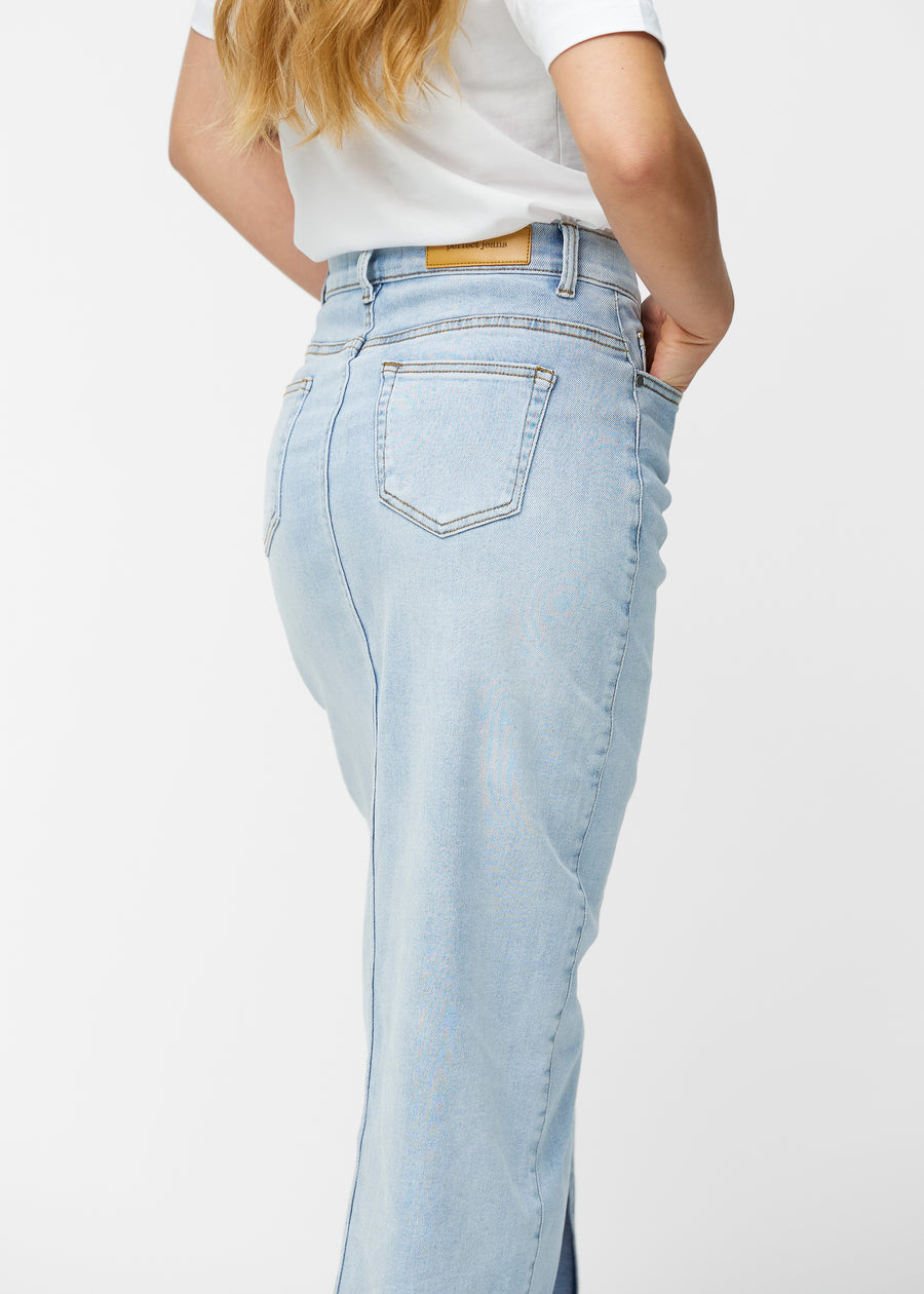 Lang, lyseblå denimnederdel i farven Waves set bagfra tæt på for at vise pasform og detaljer.