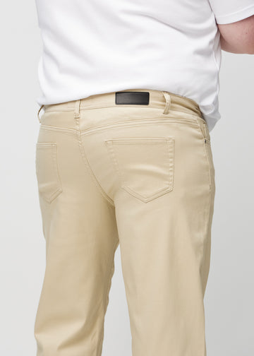 Beige regular jeans seen from the back up close on a plus-size model to show details.