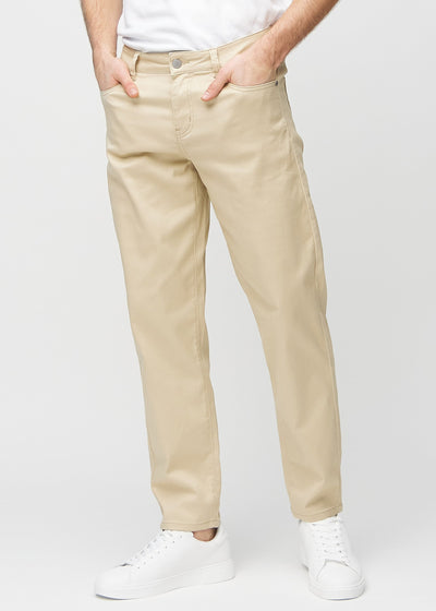 Beige regular jeans, model name Gazelles, which goes straight down the leg, seen from the front.