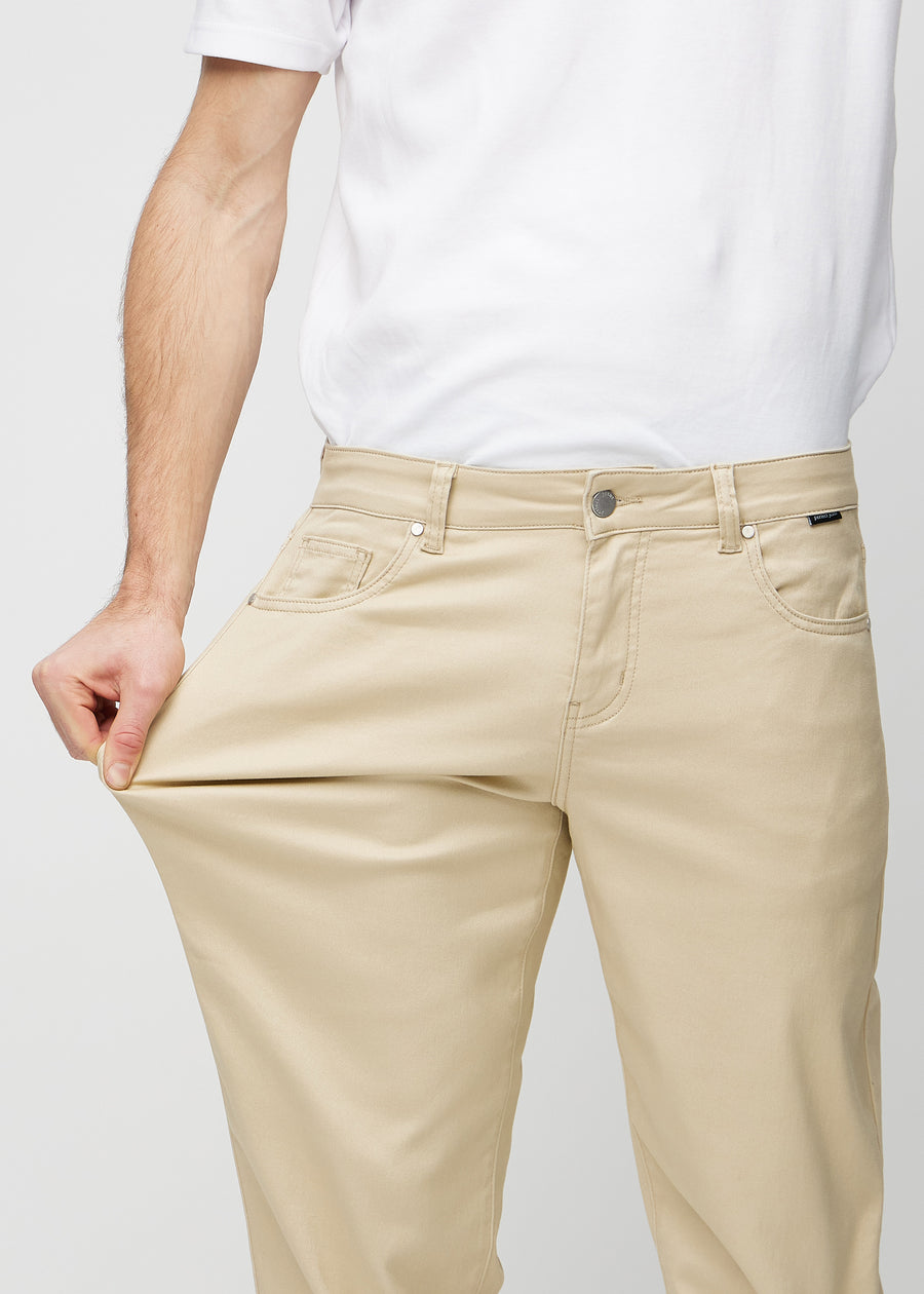 The model stretches the jeans at the thigh to show the stretch.