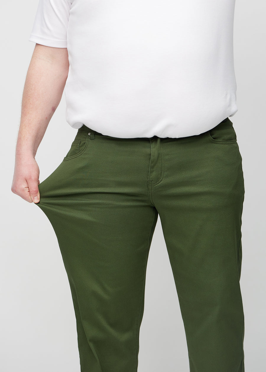 The plus-size model stretches the jeans at the thigh to show the stretch.