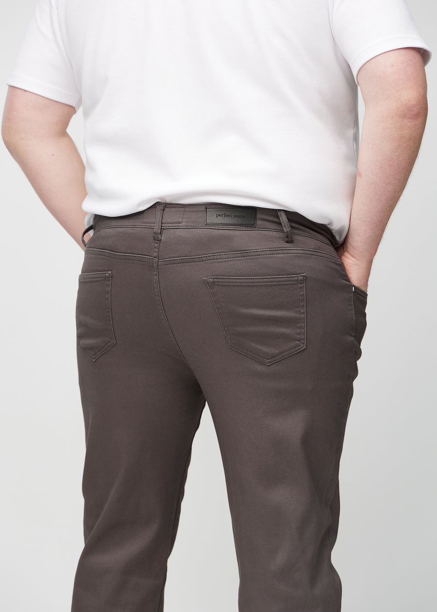 Grey-brown regular jeans seen from the back close up on a plus-size model to show details.
