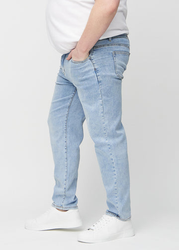 Light denim regular jeans seen from the side on a plus-size model.
