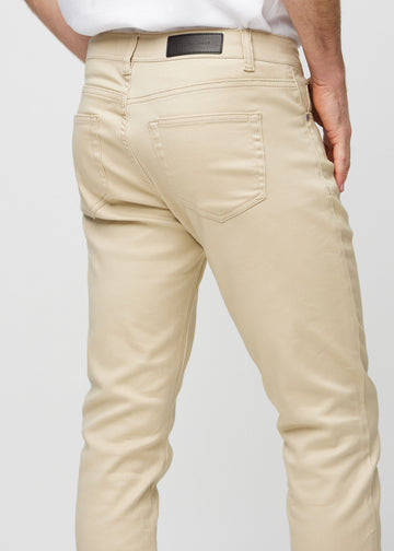 Close-up back view of beige slim jeans showing details.