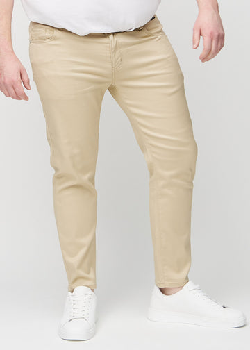 Beige slim jeans, model name Gazelles, fitted closely along the legs on a plus-size model, front view.