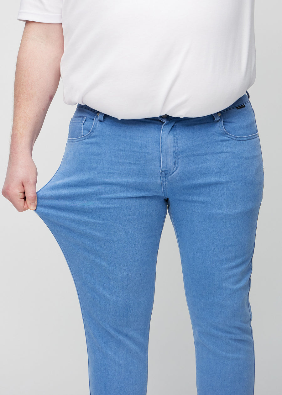 Plus-size model stretches the jeans at the thigh to show the fabric&