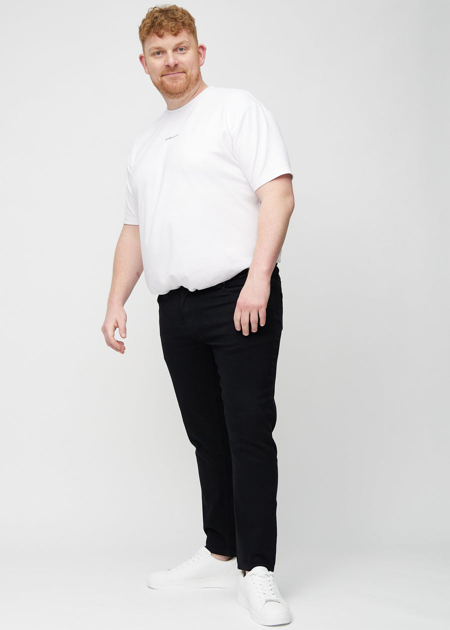 Full-length view of a plus-size model in black slim jeans.