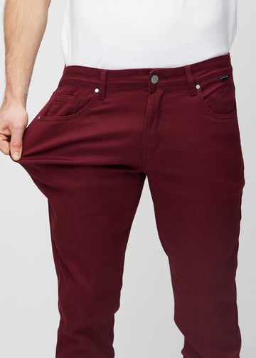 Model stretches the jeans at the thigh to show the fabric&