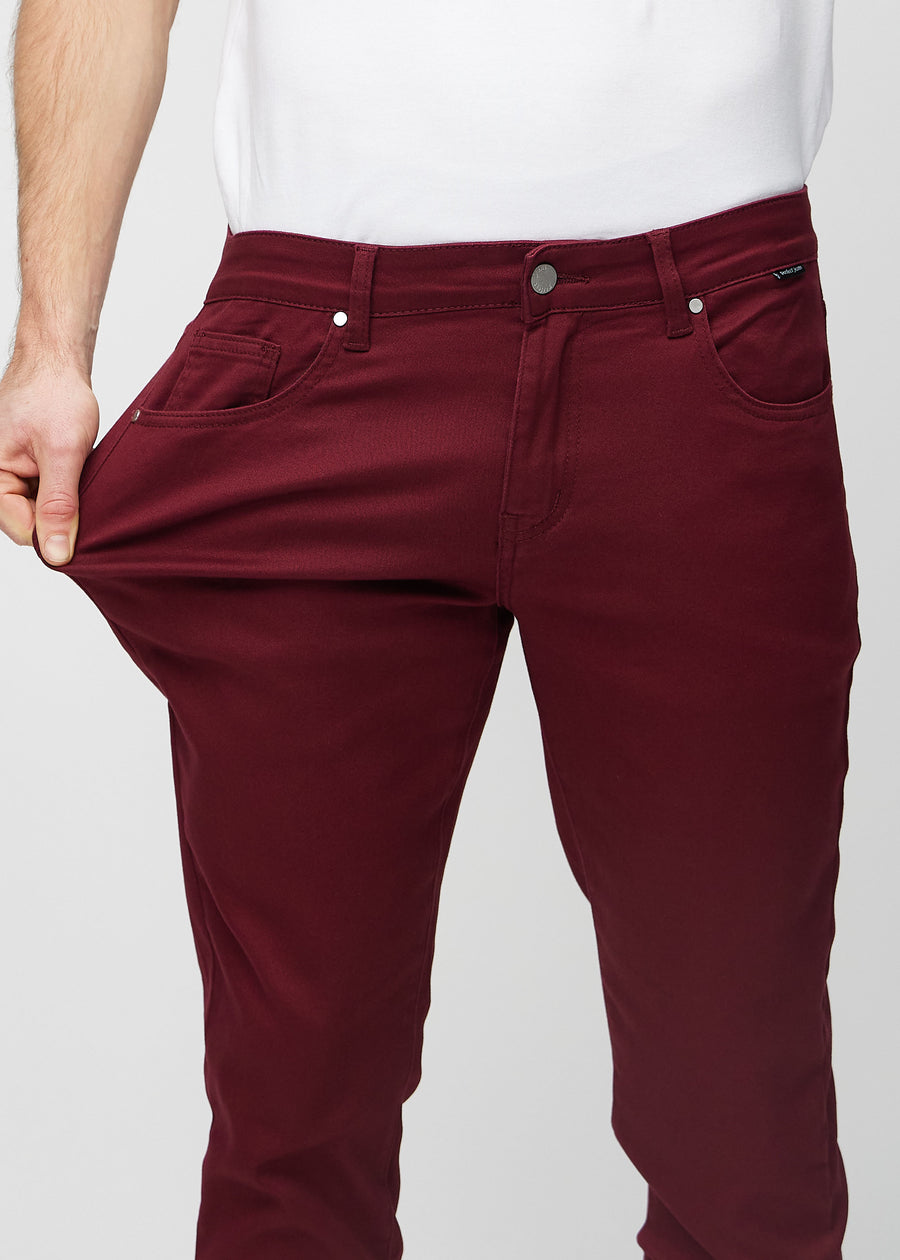 Model stretches the jeans at the thigh to show the fabric&