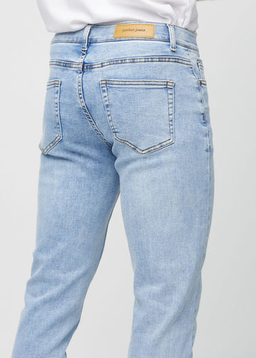 Close-up back view of light blue denim slim jeans showing details.