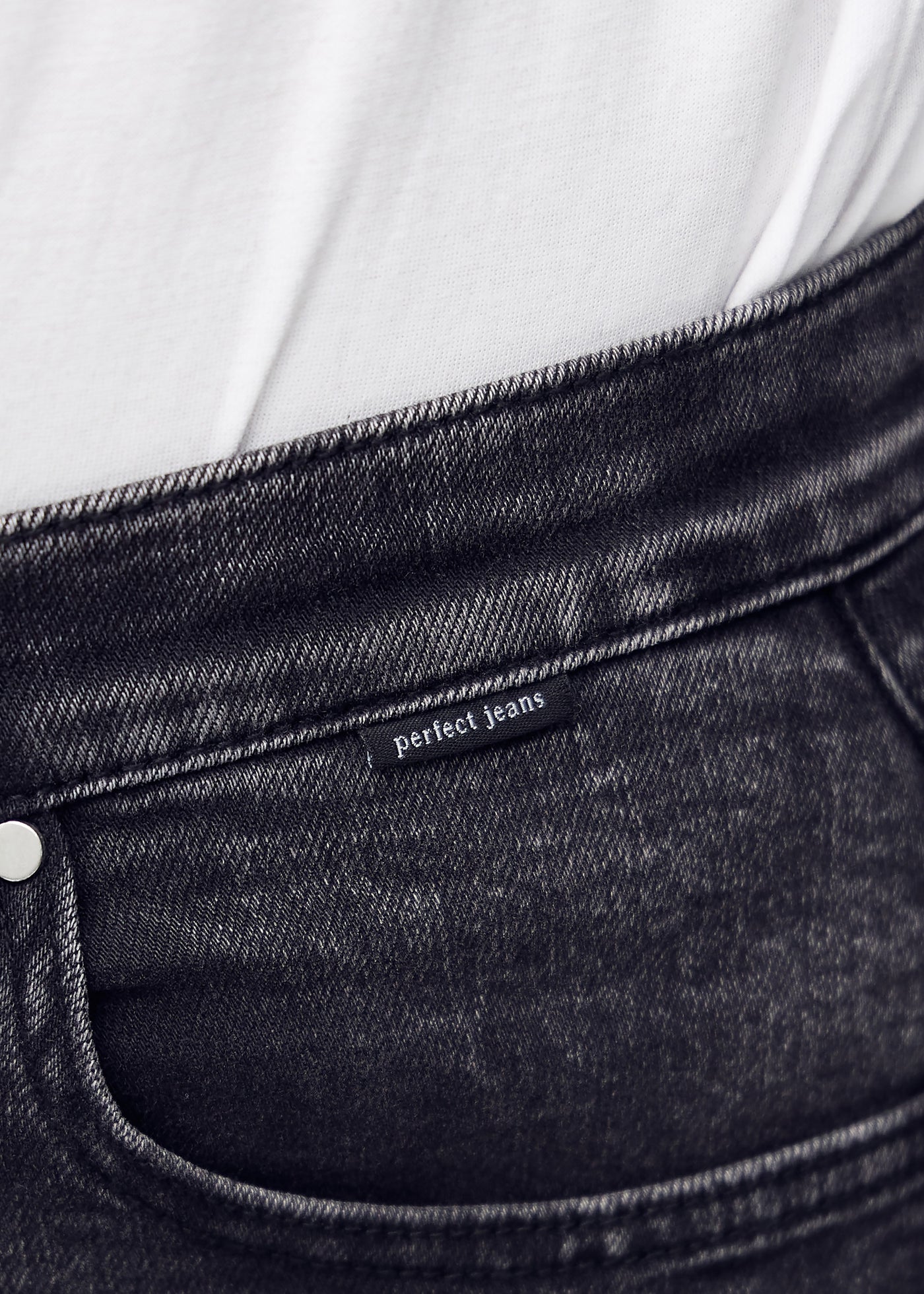 Forlommen på de mørkegrå denim  i farven Shadows – med tydeligt logo og syninger i fokus.