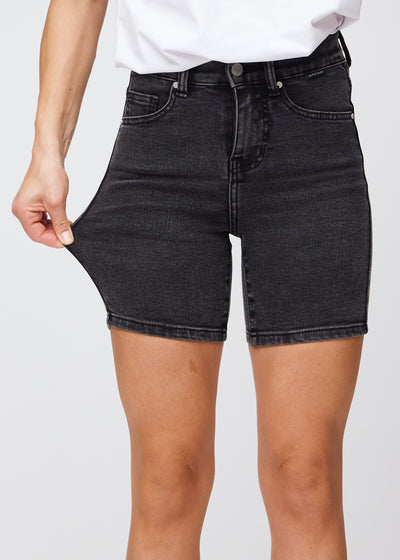 Model strækker shortsene ved låret for at vise stretch.