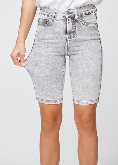 Model strækker shortsene ved låret for at vise stretch.