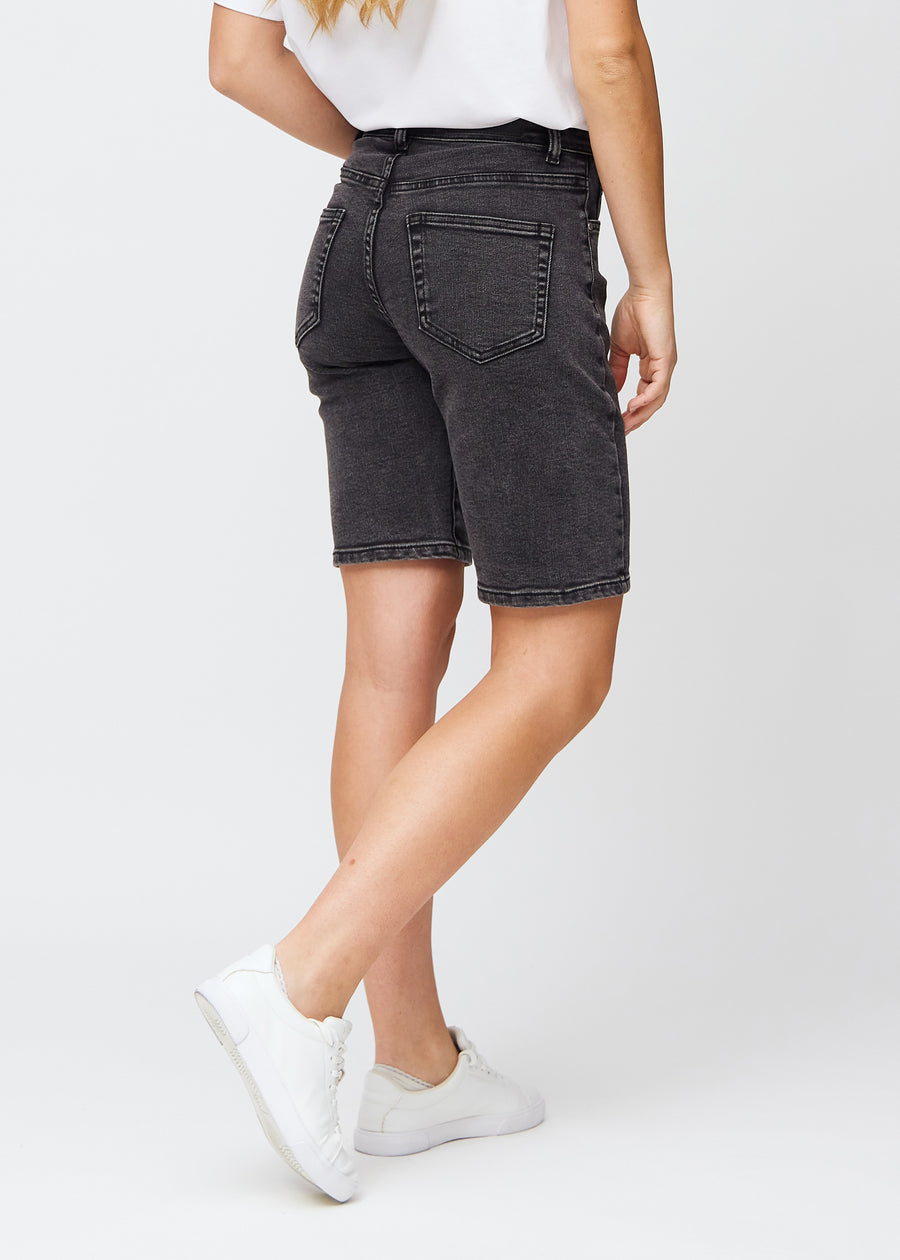 Kvinde i knælange mørkegrå denim shorts, set bagfra