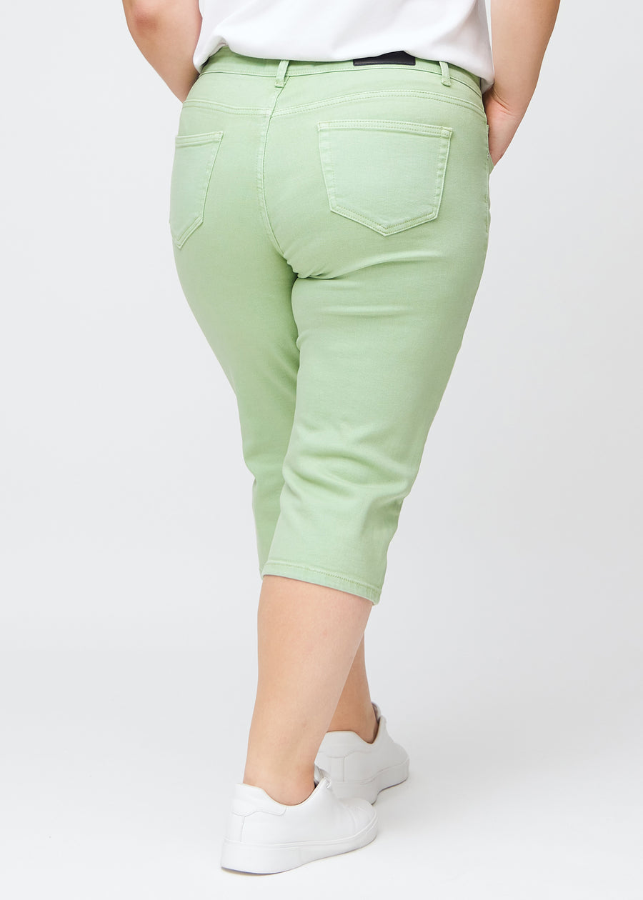 Lysegrønne slim capris set bagfra på en plus-size model – tydeligt billede af hele produktet og lommer.
