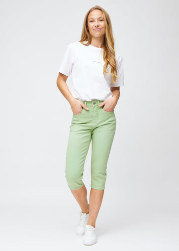 Fuldt billede af model iført lysegrønne slim capris.
