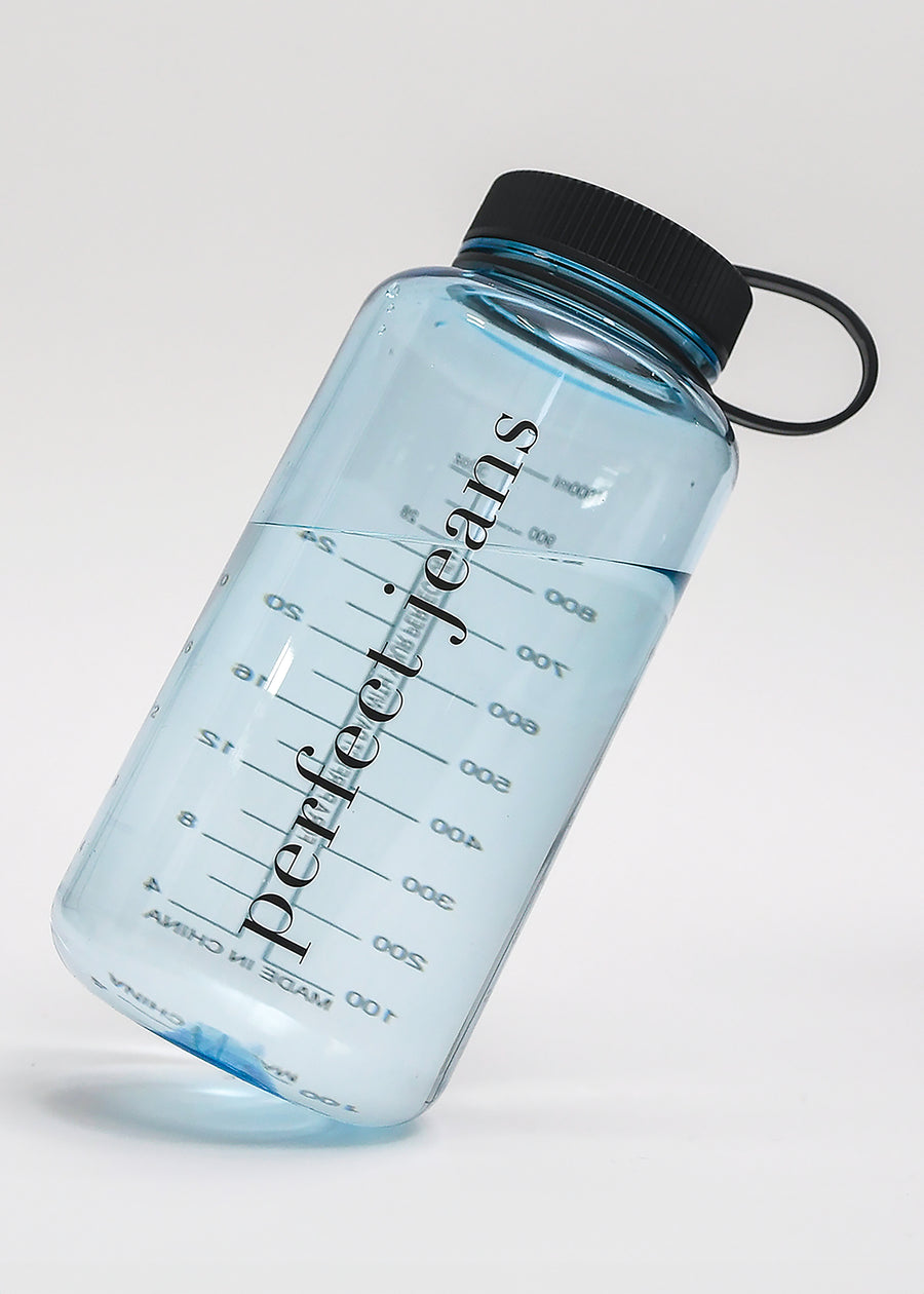 Gennemsigtig lyseblå vandflaske, der står på skrå med sort låg.
